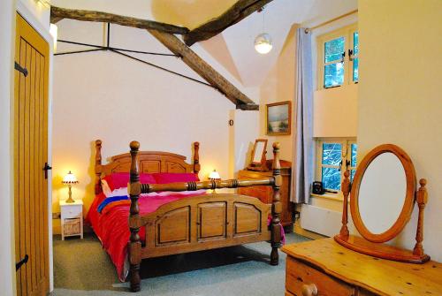 MilwichSquirrel Barn的一间卧室配有木床和镜子