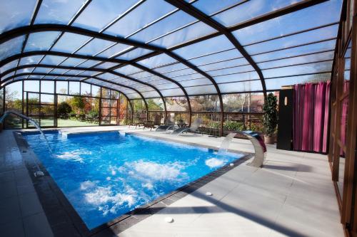 塞尔塞迪利亚勒克斯德尔波尼连酒店的一个带玻璃屋顶的室内游泳池