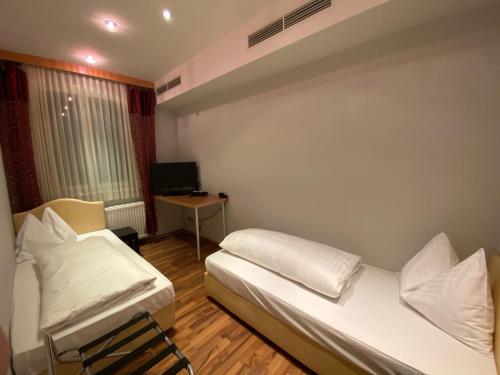 弗克拉布鲁克Ferienappartement Auerhahn的小房间设有两张床和一张书桌
