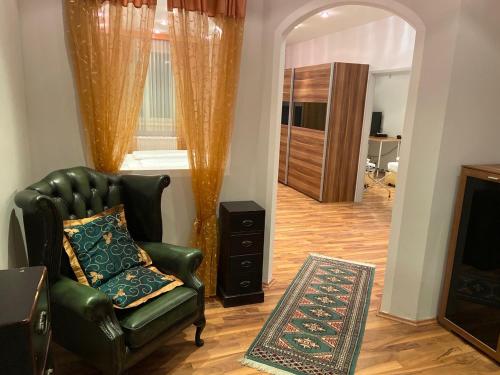 弗克拉布鲁克Ferienappartement Auerhahn的客厅设有绿色真皮座椅和壁炉