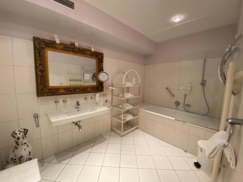 弗克拉布鲁克Ferienappartement Auerhahn的一间带水槽、浴缸和镜子的浴室