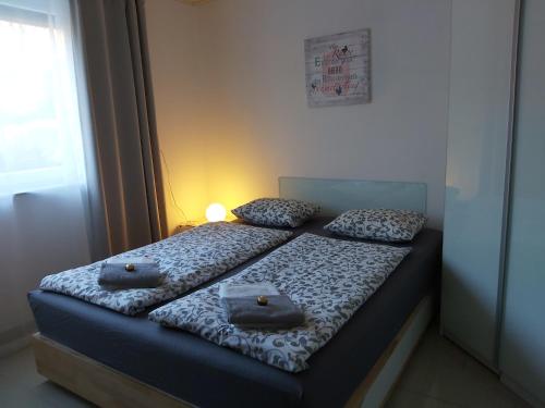 克拉根福Relax-Apartment mit Sauna的一间卧室配有两张带毛巾的床