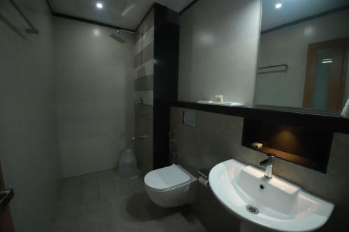 MattanūrGREEN PLANET HOTEL的一间带水槽、卫生间和镜子的浴室