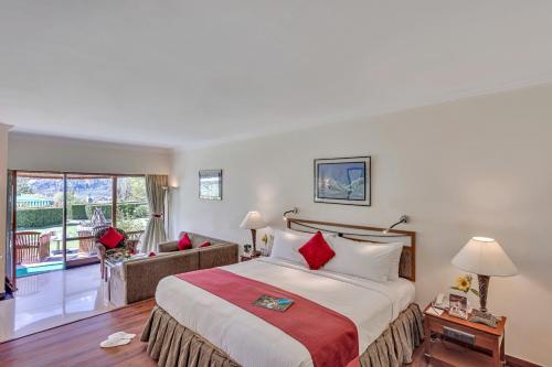 纳加尔Club Mahindra White Meadows Manali的酒店客房设有一张床和一个阳台。
