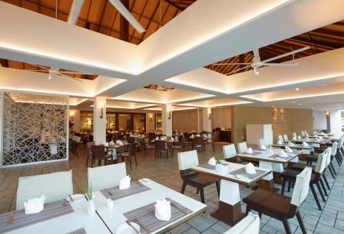 七岩Veranda Resort & Villas Hua Hin Cha Am的一间餐厅,房间内设有白色的桌椅