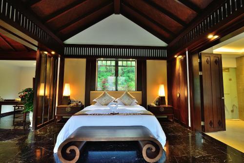 张家界张家界禾田居度假酒店的一间卧室设有一张大床和一个大窗户