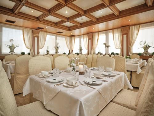 因斯布鲁克朗姆好酒店的一间设有白色桌椅的用餐室