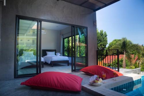 通奈潘海滩T villas的两个红色枕头坐在游泳池旁