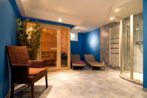 博恩Ferienhaus Zander mit Sauna的一间拥有蓝色墙壁和椅子的房间和玻璃门