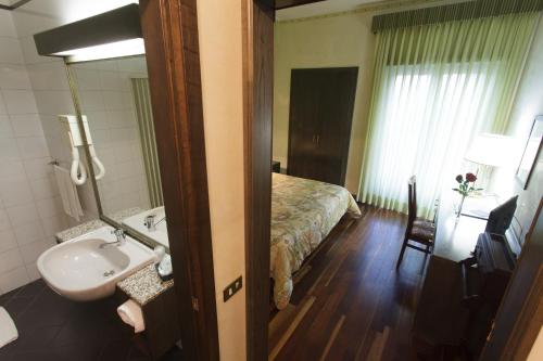 弗罗西诺内Astor Hotel Vintage的一间带水槽的浴室和一张位于客房内的床