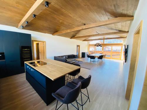 弗拉绍AlpinLodge Flachau的厨房和带木制天花板的客厅