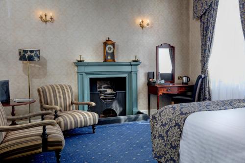 皮克林Best Western Forest and Vale Hotel的酒店客房设有壁炉、床和镜子