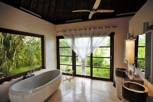 奔巴岛Chuiba Bay lodge的一间带大浴缸和大窗户的浴室