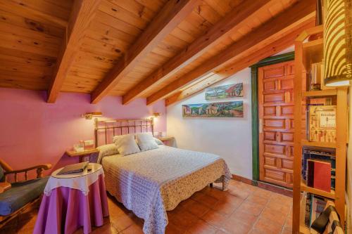阿尔玛格鲁阿特德斯坎索乡村民宿的一间带一张床的卧室,位于带木制天花板的房间内