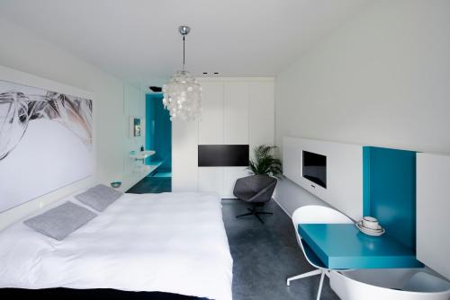 Opglabbeek超越住宿加早餐酒店的卧室配有白色的床和蓝色的书桌