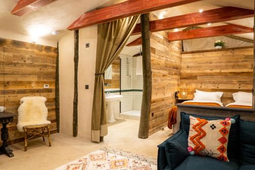 LangleyThe Potting Shed Maidstone的一间带木墙和一张床的卧室以及一间浴室。