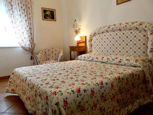 比萨Il Campanile II Locazione Turistica的一间卧室配有一张带鲜花毯子和椅子的床。