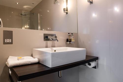 LamberhurstThe Vineyard Lamberhurst的浴室设有白色水槽和镜子