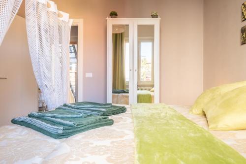 博洛尼亚CASA PETRONIO APARTMENTS BOLOGNA CENTER的一间卧室配有一张带绿毛巾的床