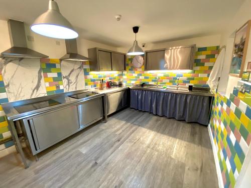 伦敦斯马特罗素广场旅舍的厨房铺有木地板,配有不锈钢用具