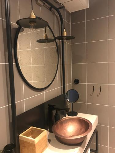 菲斯克拜克希尔Slipens Hotell的一间带铜盥洗盆和淋浴的浴室
