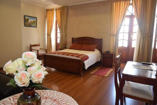 基多卡萨莫特瑞酒店的一间卧室配有一张床和一张花瓶桌子