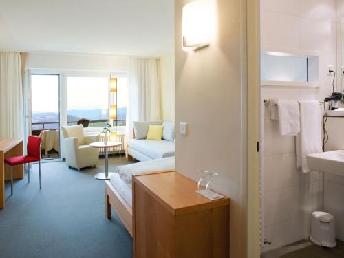 洛伊费尔芬根拉姆萨奇巴德酒店的酒店客房设有沙发和客厅。