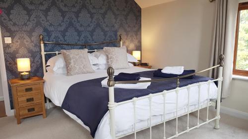 布德橡树小屋住宿加早餐旅馆的一间卧室配有一张带蓝白色床单的大床