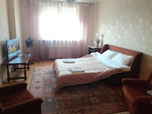 基辅Gloria park apartment的一间卧室设有一张大床和一个窗户。