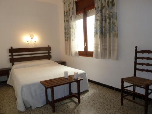 埃勒凡达尔Villa Service - Apartamentos Aransol的卧室配有床、椅子和窗户。