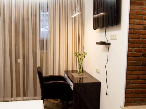 第比利斯BFG Suit Mtatsminda的客房设有书桌、椅子和窗户。