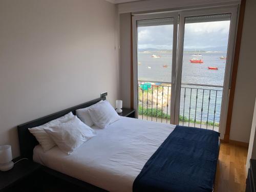 艾利亚德亚罗萨Apartamento en la Isla con vistas al Mar的一间卧室配有一张床,享有水景