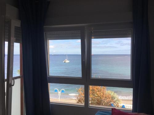 休达Estudio frente al mar的水中船的窗户,享有大海美景