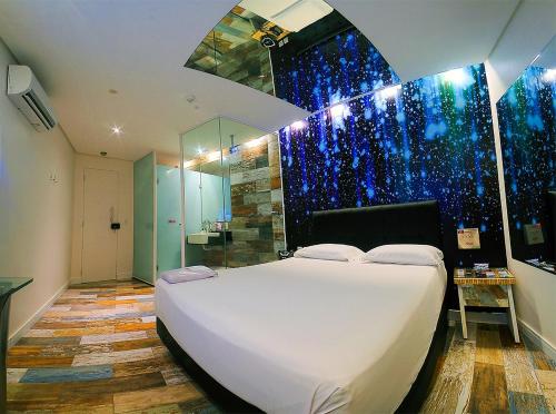累西腓Nexos Motel Tamarineira (Adult Only)的一间带白色大床的卧室和一间浴室