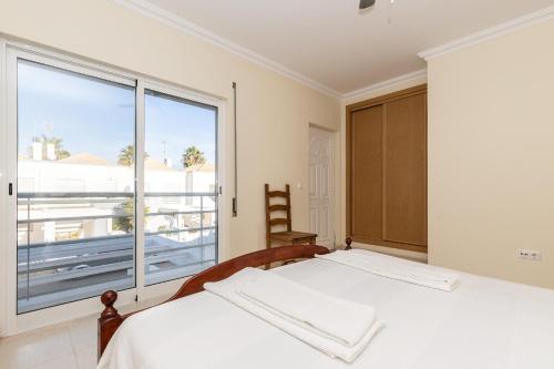 曼塔罗塔Montesol by ALGARVEMANTA的一间卧室设有一张床和一个大窗户