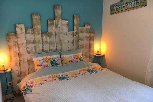 凯恩Un petit coin de paradis au centre ville de Caen的一间卧室配有一张带木制床头板的床