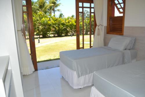 普拉亚多Praia do Forte, Piscinas Naturais的一间卧室设有两张床,享有庭院的景色