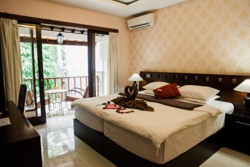 乌布普图王之子避世旅馆的一间带大床的卧室和一个阳台