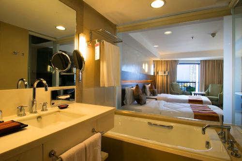 马尼拉Century Park Hotel的一间带床、浴缸和水槽的浴室