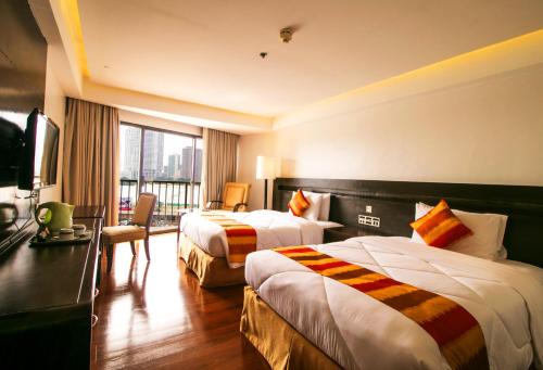 马尼拉Century Park Hotel的酒店客房设有两张床和电视。