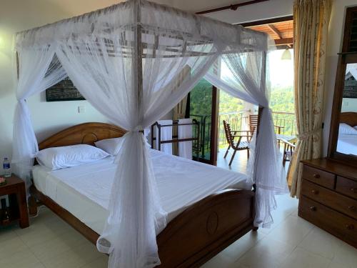 佩勒代尼耶Lotus Villa Kandy的一间卧室设有一张天蓬床和一个阳台