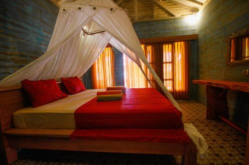 吉利阿尔斯佳村庄酒店的一间卧室配有一张带蚊帐的床