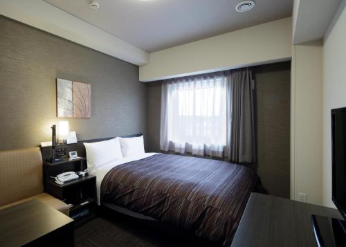 富士市露樱酒店 新富士站南(Hotel Route Inn Shinfuji Ekiminami)的酒店客房设有床和窗户。