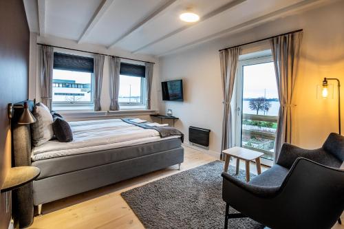 霍尔拜克希德斯博安酒店的一间卧室配有一张床、一把椅子和窗户。