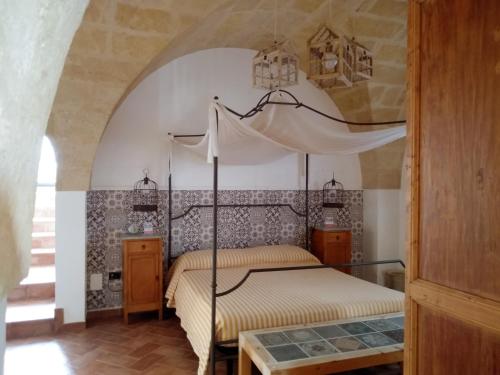 CrispianoMasseria Urbana的一间卧室,卧室内配有一张天蓬床