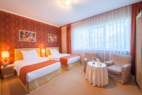 克拉斯诺达尔迈如泰尔酒店的酒店客房设有两张床和一张桌子。