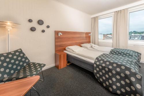 桑内斯斯维尔酒店 的卧室配有床、椅子和窗户。
