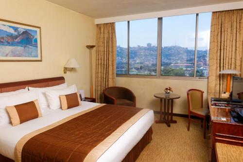 塔那那利佛马达加斯加卡尔顿酒店的酒店客房设有一张床和一个大窗户