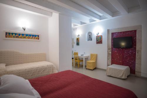 锡拉库扎阿里特斯瓦坎兹住宿加早餐酒店的一间卧室配有一张床、一台电视和一张桌子