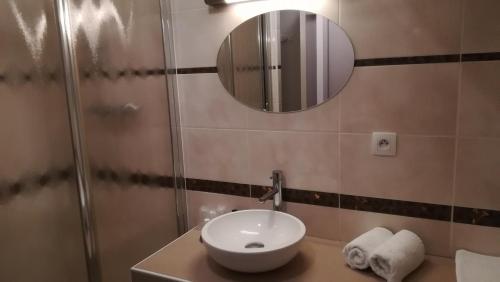 奥特朗Hôtel Restaurant Les Tilleuls的一间带水槽和镜子的浴室